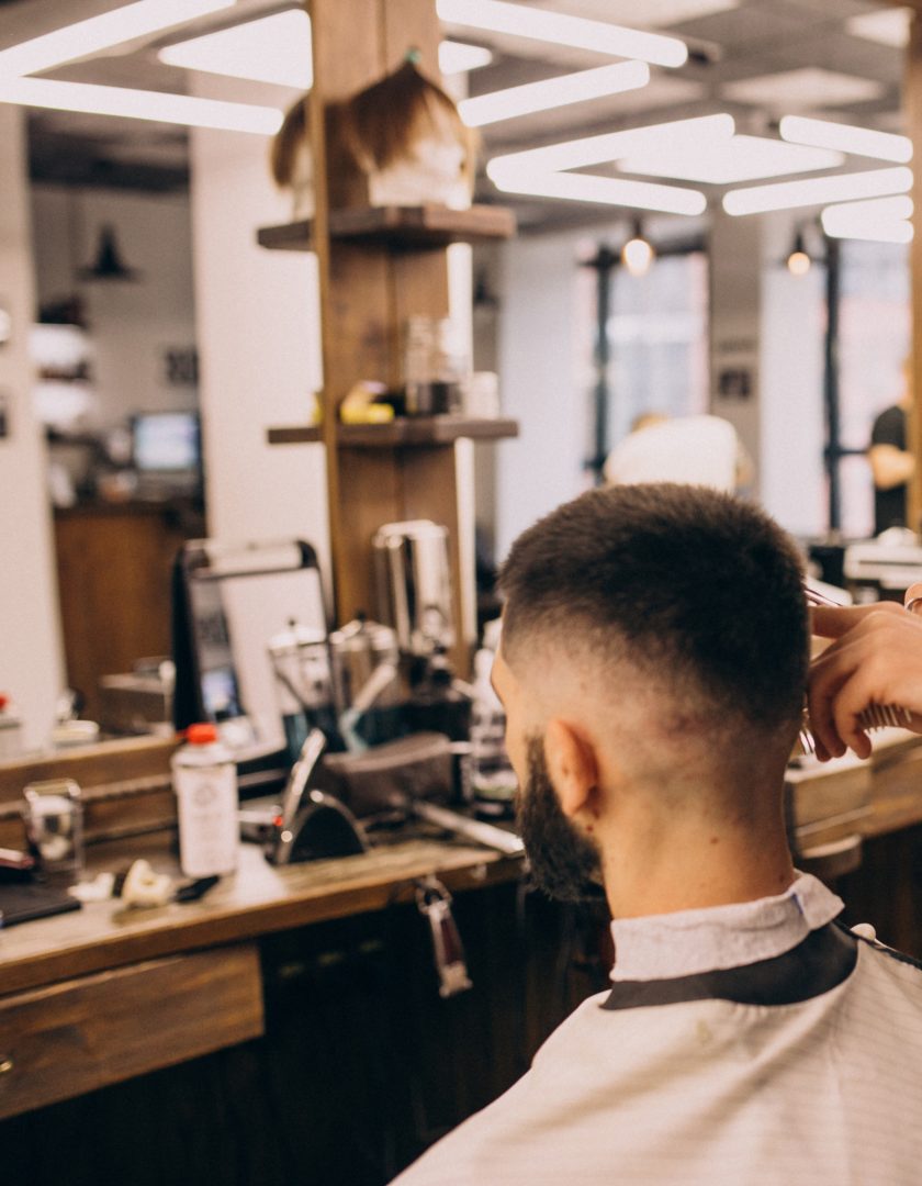 Man at a barbershop salon doing haircut and beard trim